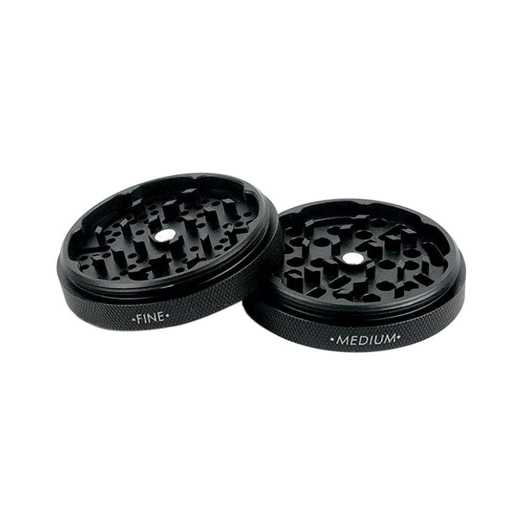 Angled close-up of two open Ryot Gr8Tr Jar Body Grinder halves in rose gold-toned metal showing textured outer rims and staggered internal teeth.