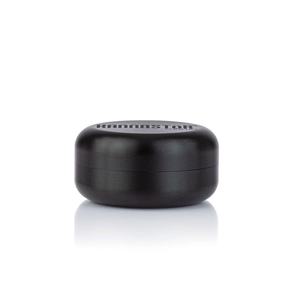 Front-facing view of the black Ryot Gr8Tr Solid Body Grinder resting on a reflective white surface with soft overhead lighting.
