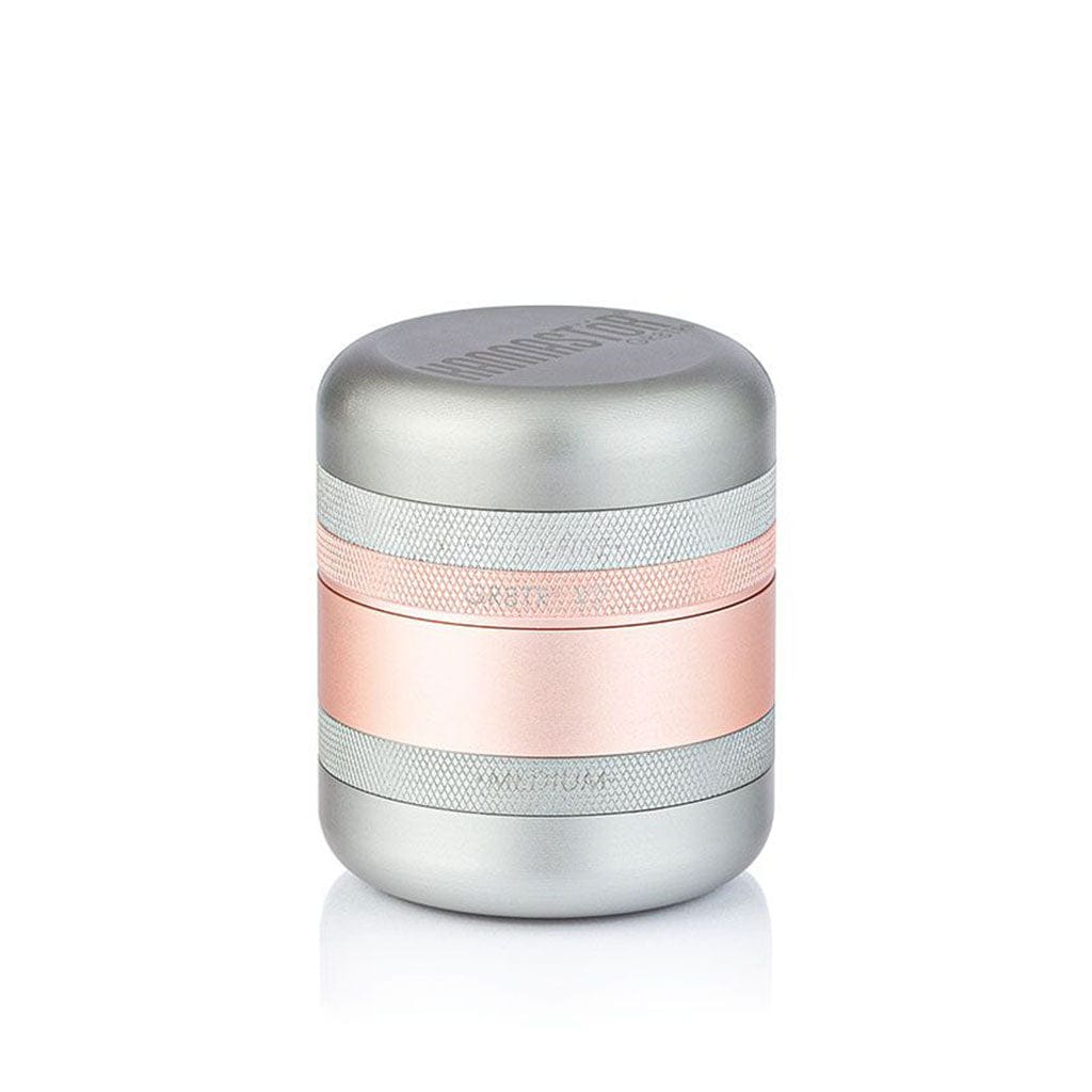 Centered studio shot of a silver and rose-gold cylindrical Ryot Gr8Tr Solid Body Grinder with knurled bands and soft top lighting