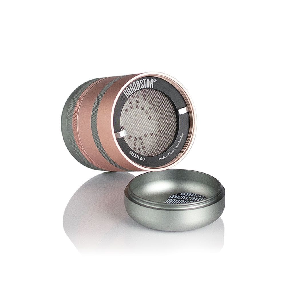Angled studio shot of the Ryot Gr8Tr Solid Body Grinder showing its rose-gold and gunmetal stacked sections with a visible mesh screen and lid.