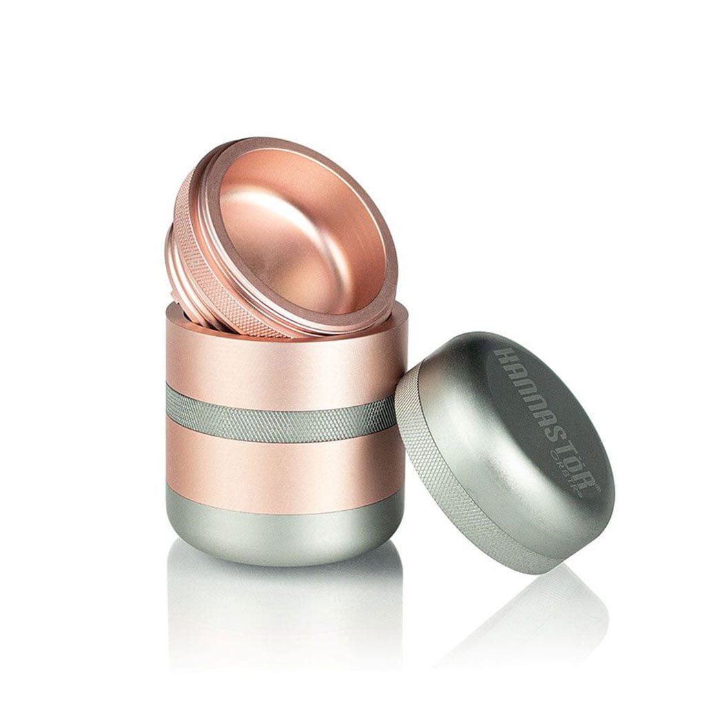 Three-quarter front view of the rose-gold and silver Ryot Gr8Tr Solid Body Grinder with its lid removed and resting beside the threaded, reflective body.