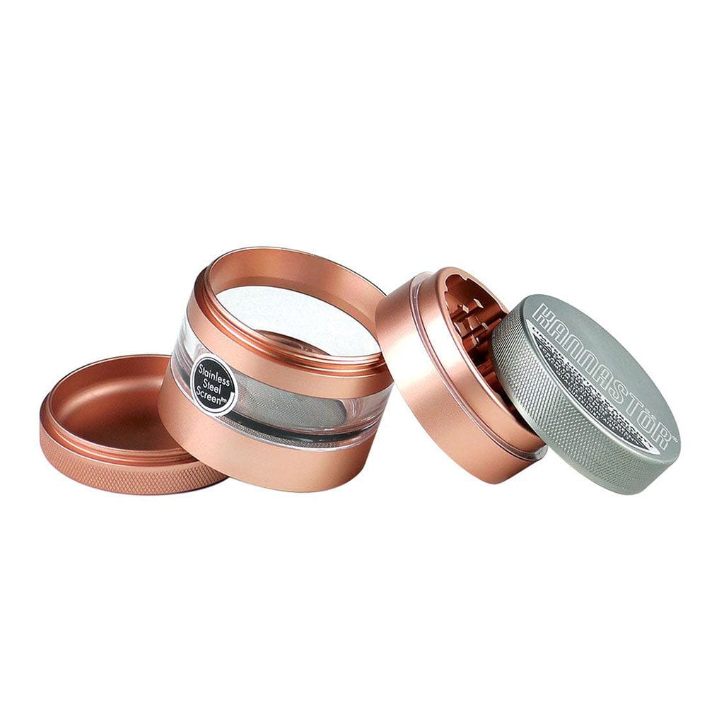 Angled close-up of the rose-gold Ryot 4Pc Jar Body Grinders showing the disassembled lids, clear jar section with stainless-steel screen, and knurled metal top.
