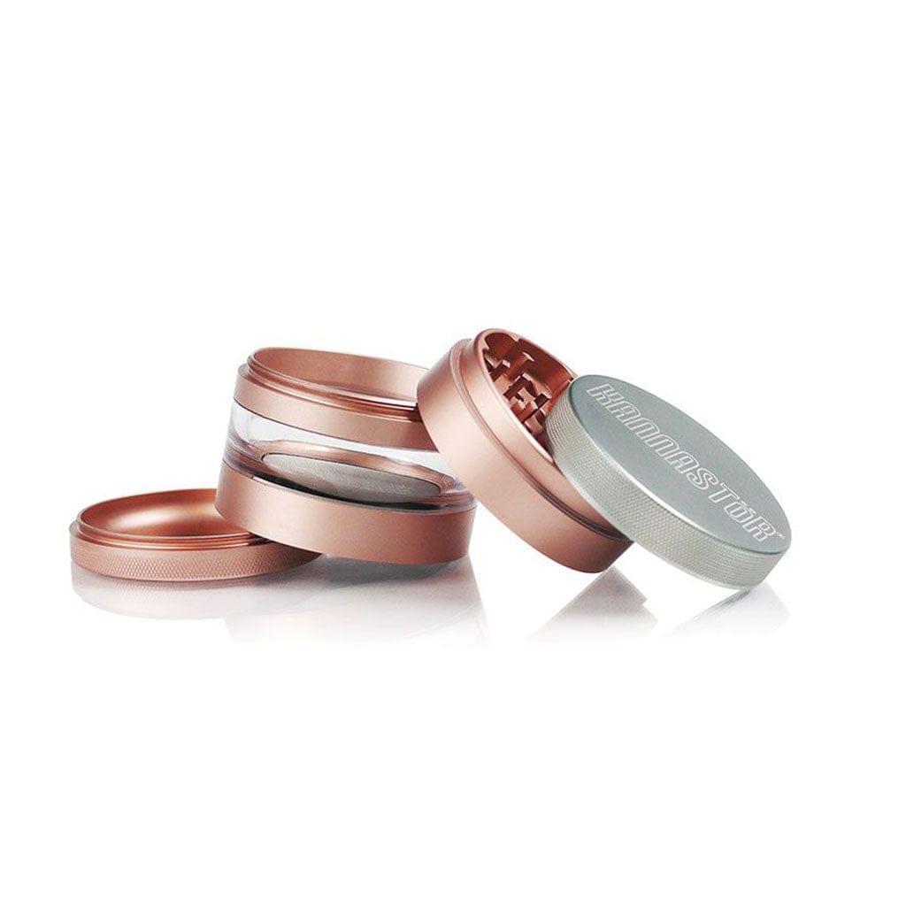 Angled close-up of the rose-gold Ryot 4Pc Jar Body Grinders with one lid showing knurled silver top and a clear middle chamber.