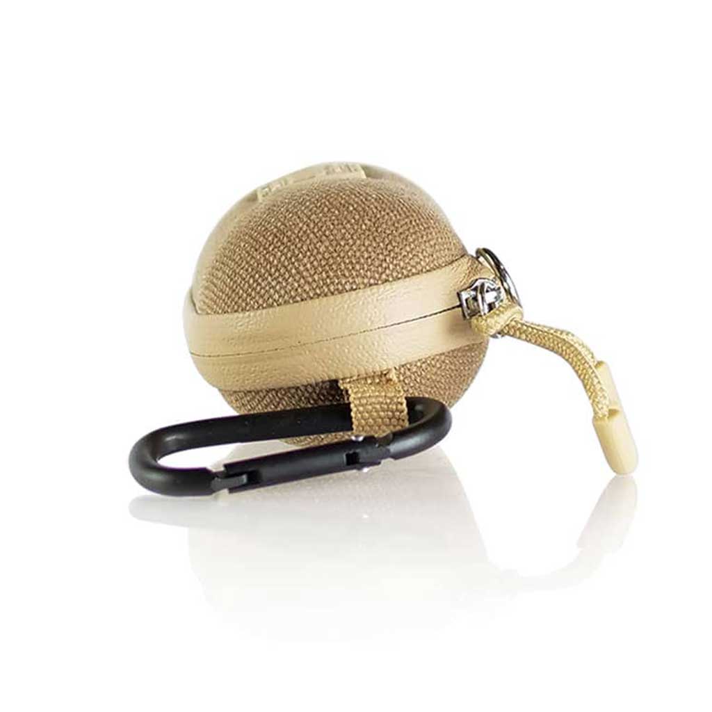 Close-up of a tan, spherical Ryot Hardcase resting on a reflective white surface with a black carabiner and short cord attached.