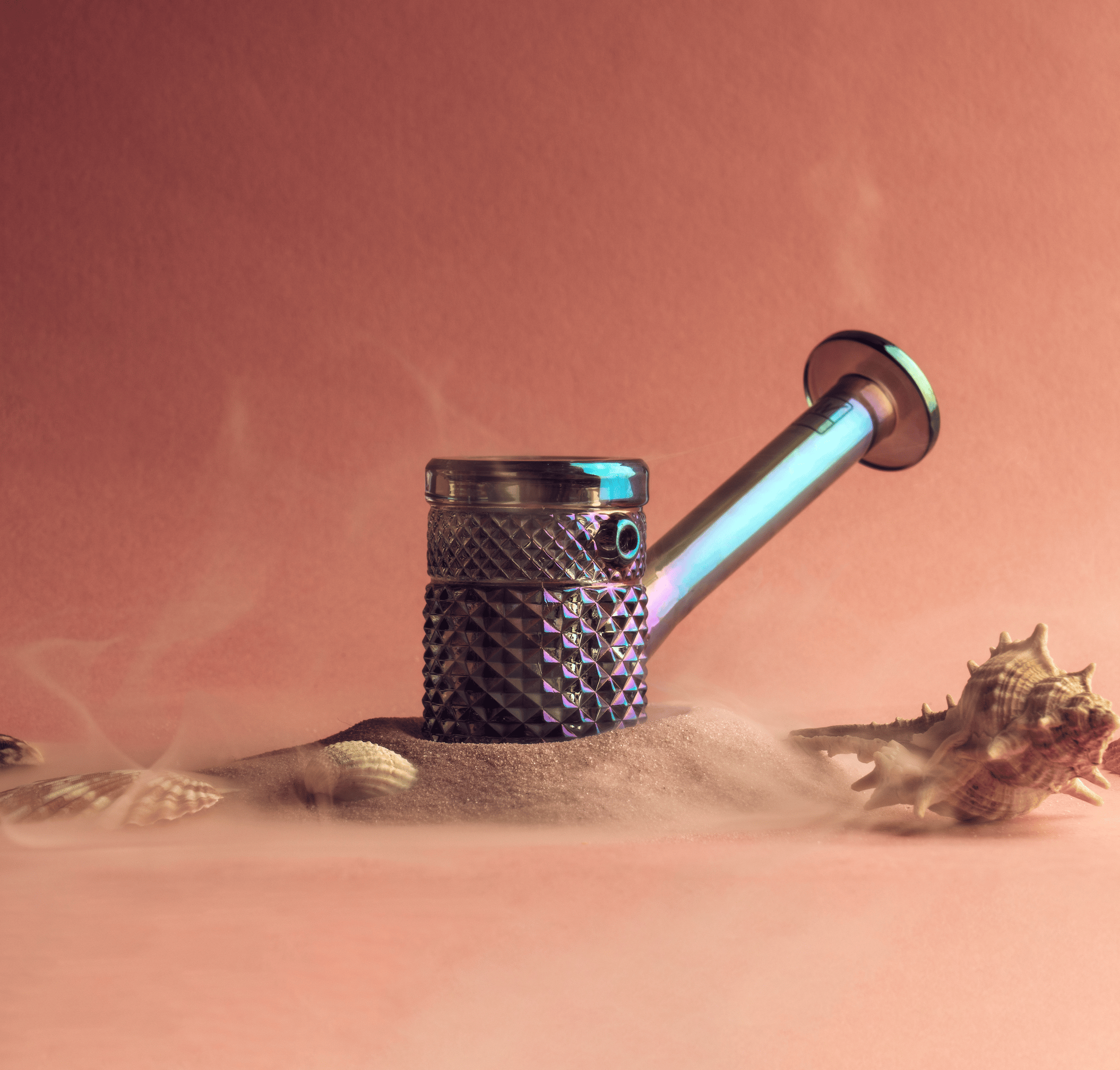 Close-up angled view of the Twenties Collection Hand Pipe | Mermaid resting in sand with seashells against a warm coral background.