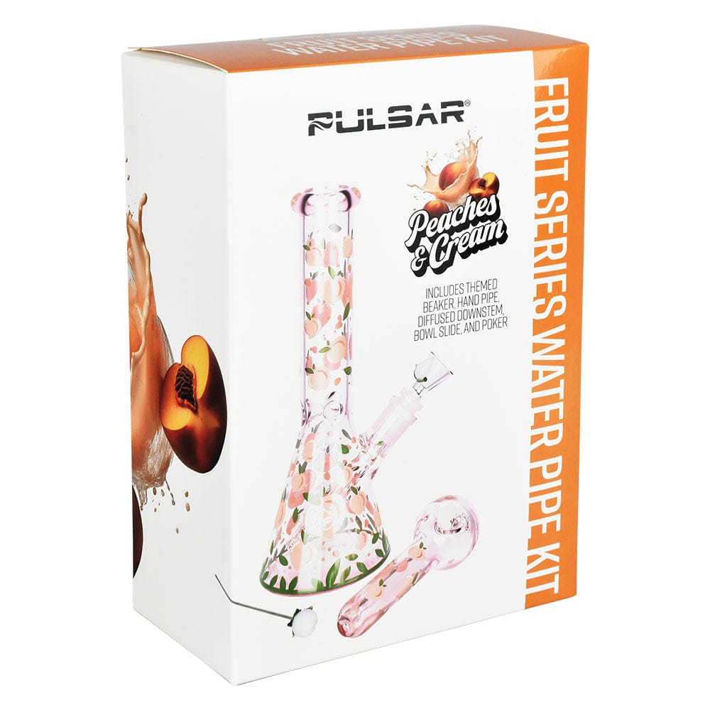 Three-quarter view of the boxed Pulsar Fruit Series Peaches & Cream Herb Pipe Glow Duo - 10" / 14Mm F showing the peach-patterned glass beaker and matching hand pipe on white background.