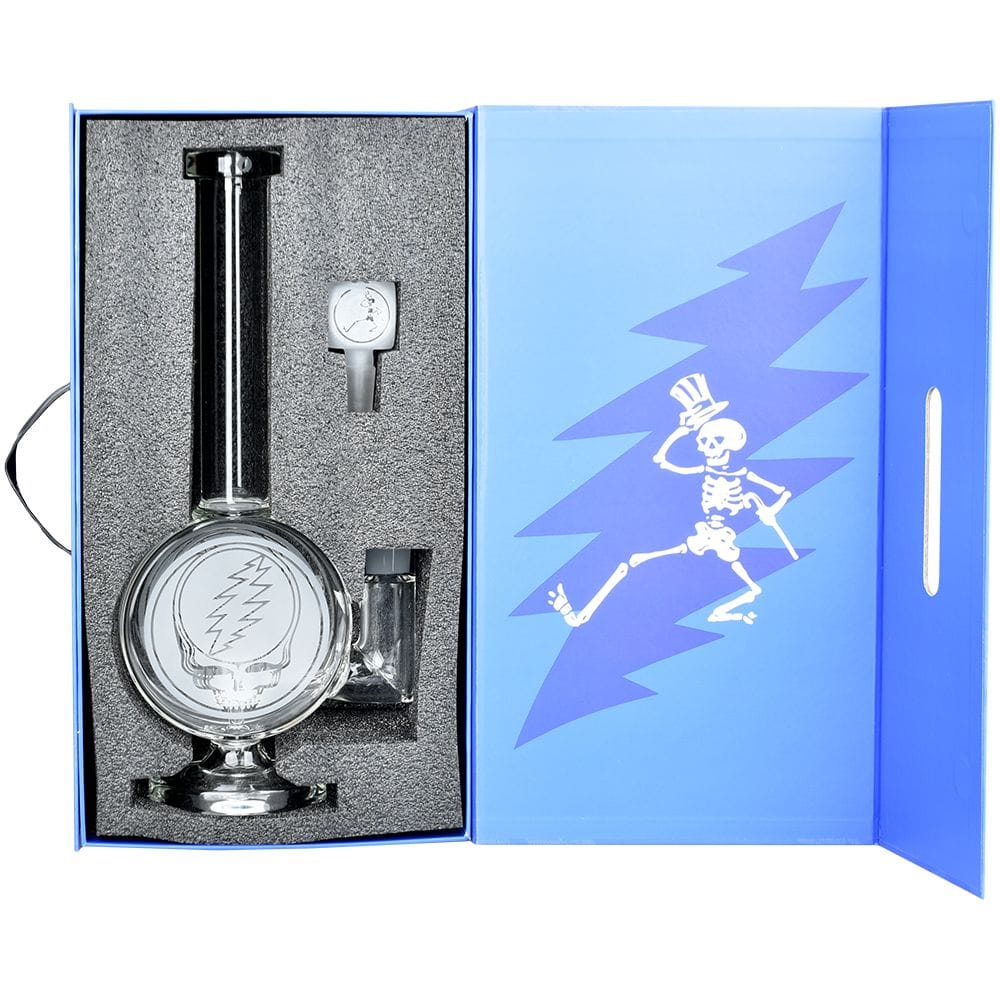 Top-down view of the Grateful Dead X Pulsar Round Steal Your Face Water Pipe - 14.5" / 19Mm F nestled in foam with blue branded box art.