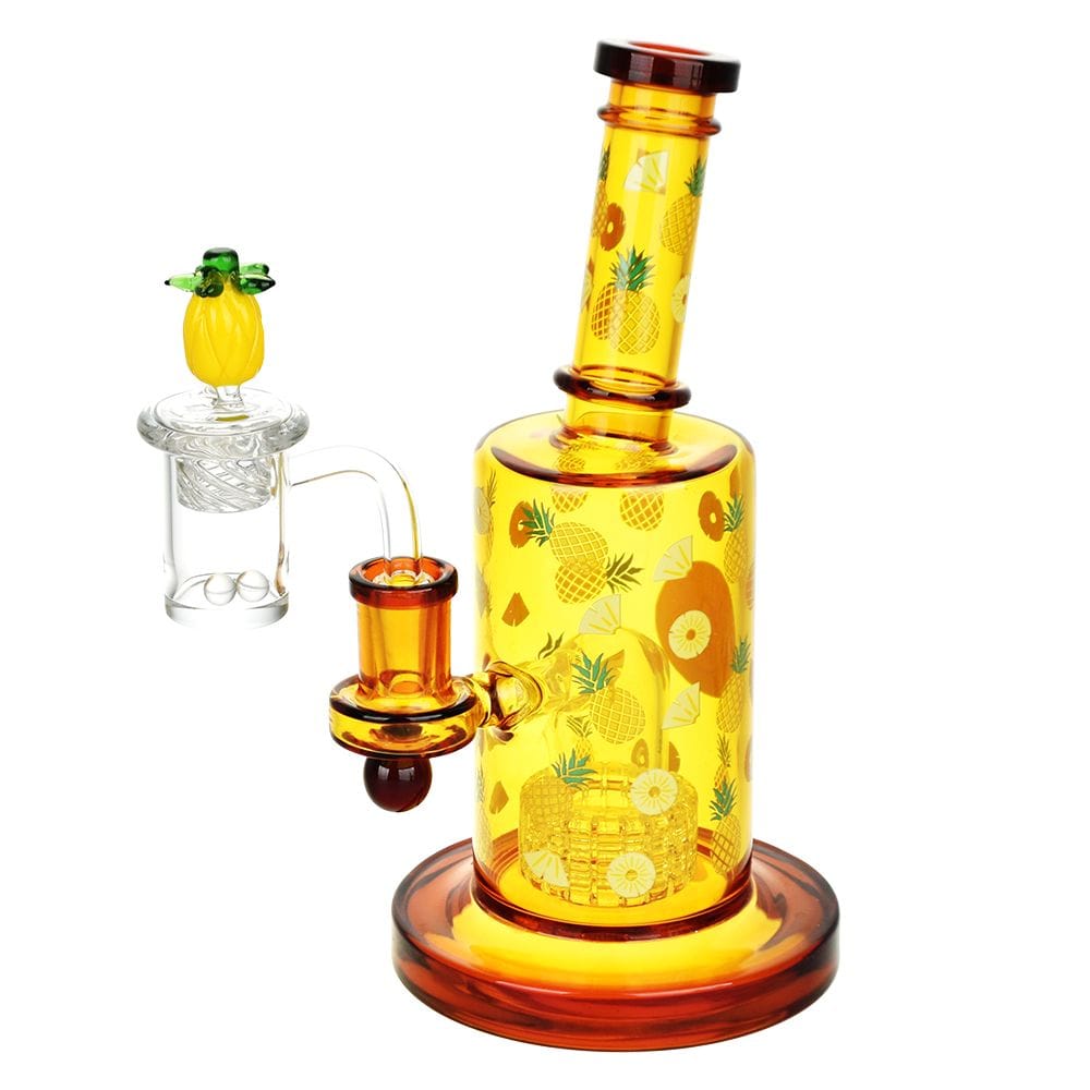 Angled front view of the Pulsar Fruit Series Pineapple Express Glow In The Dark Dab Rig Kit - 8" / 14Mm F, a translucent amber rig decorated with small pineapple motifs against a white background