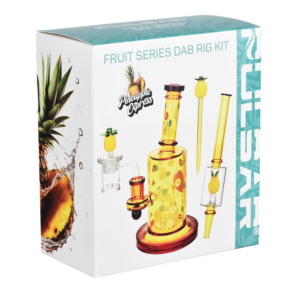 Three-quarter front view of the box showing the Pulsar Fruit Series Pineapple Express Glow In The Dark Dab Rig Kit - 8" / 14Mm F artwork featuring a yellow pineapple-patterned dab rig and accessories.