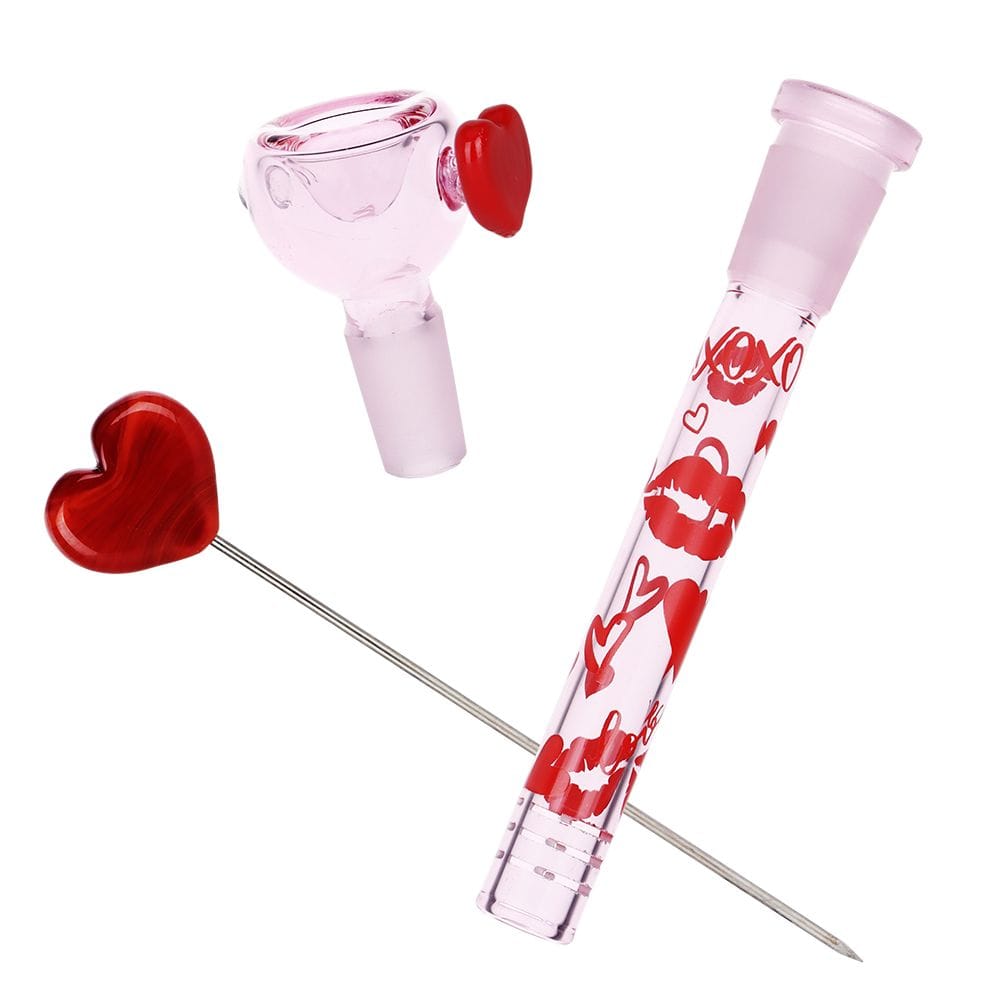 Angled top-down view of the Pulsar Valentine'S Xoxo Glass Beaker Water Pipe & Hand Pipe Set - 10" / 14Mm F showing a pink glass bowl with red heart accents and a matching clear pink hand pipe printed with red lips and hearts.