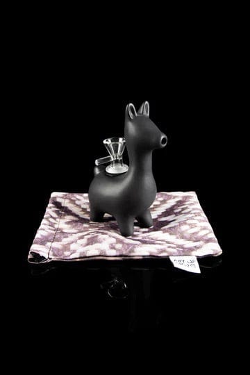 A front view of the Alpaca Bubbler resting on a patterned cloth, showcasing its unique animal-shaped design.