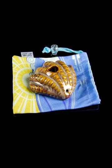 Front view of the Clam Shell Pipe resting on a blue and yellow patterned cloth.