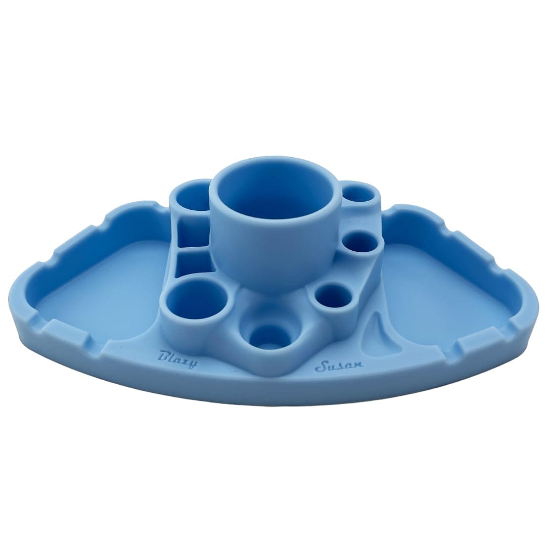 Front-facing shot of a teal Blazy Susan Deluxe Dab Station on a white background showing its central round cup, multiple circular wells, and two flat side trays.