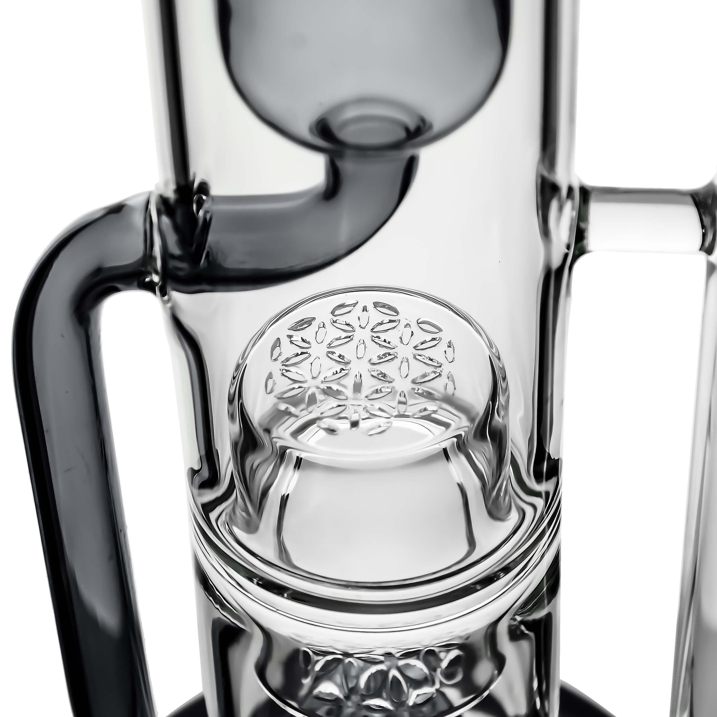 A close-up, angled view of the FLOWER KLEIN BONG’s joint, showcasing the clear glass and intricate internal details.