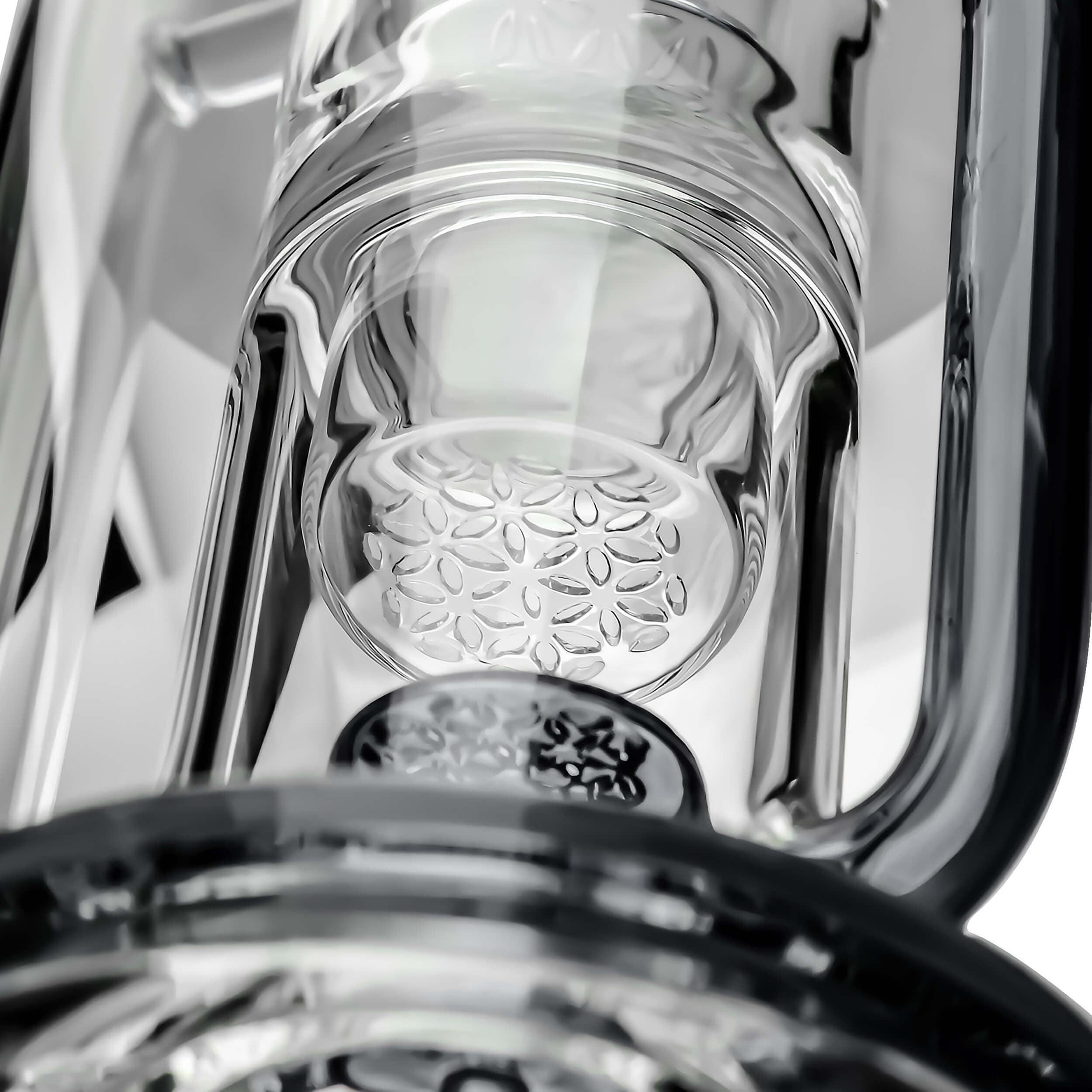 A close-up, angled view inside the FLOWER KLEIN BONG, showing its clear glass construction and internal chamber details.