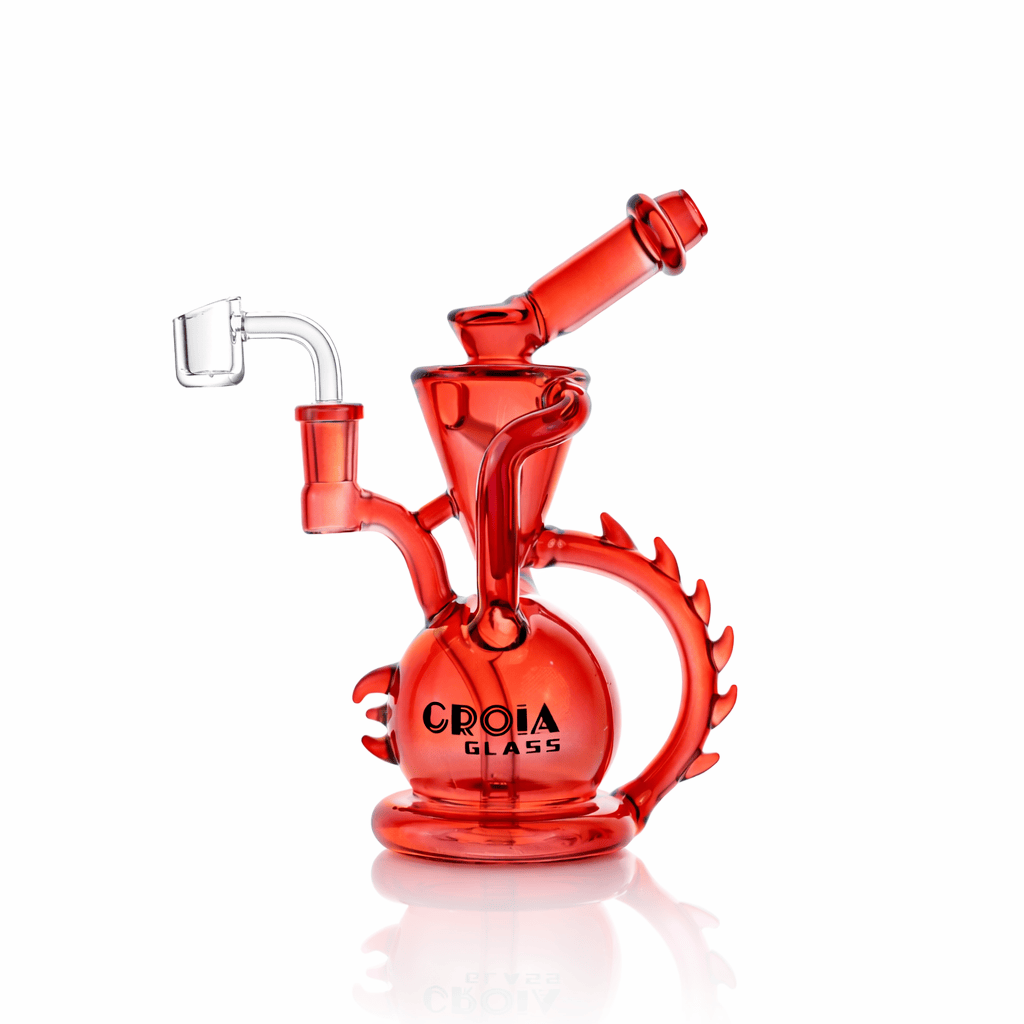Angled front view of the Croia Glass 10" Dragon Spine Recycler Dab Rig in translucent red with a round base, spiked circular handle, and clear quartz banger.