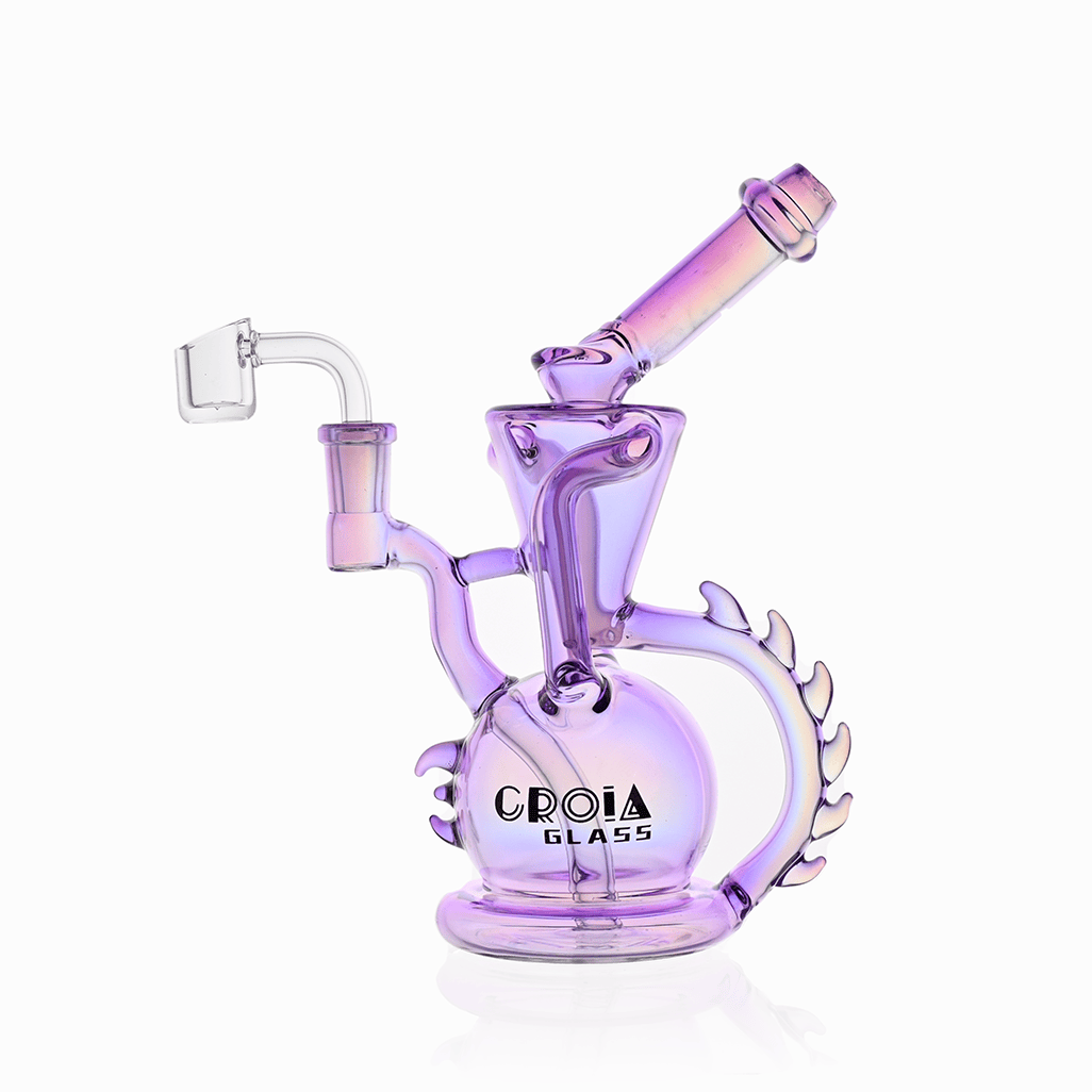 Angled studio shot of the Croia Glass 10" Dragon Spine Recycler Dab Rig in iridescent purple, showing its spherical base, curved spine-like handle, angled mouthpiece and clear quartz banger.