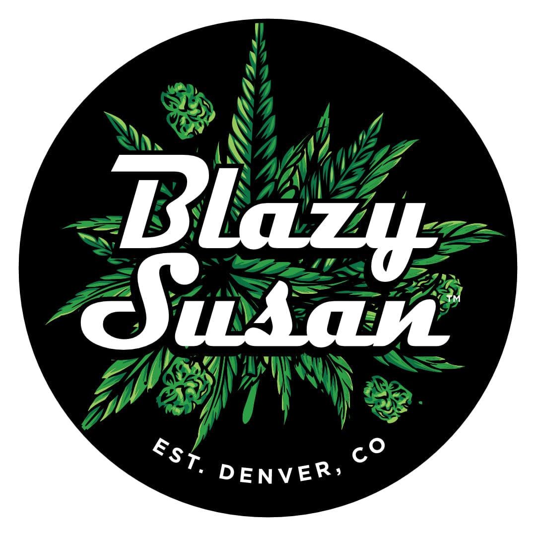 Top-down view of the Blazy Susan 8" Silicone Tray Mat showing a circular black mat printed with green cannabis leaf graphics and bold white "Blazy Susan" lettering.