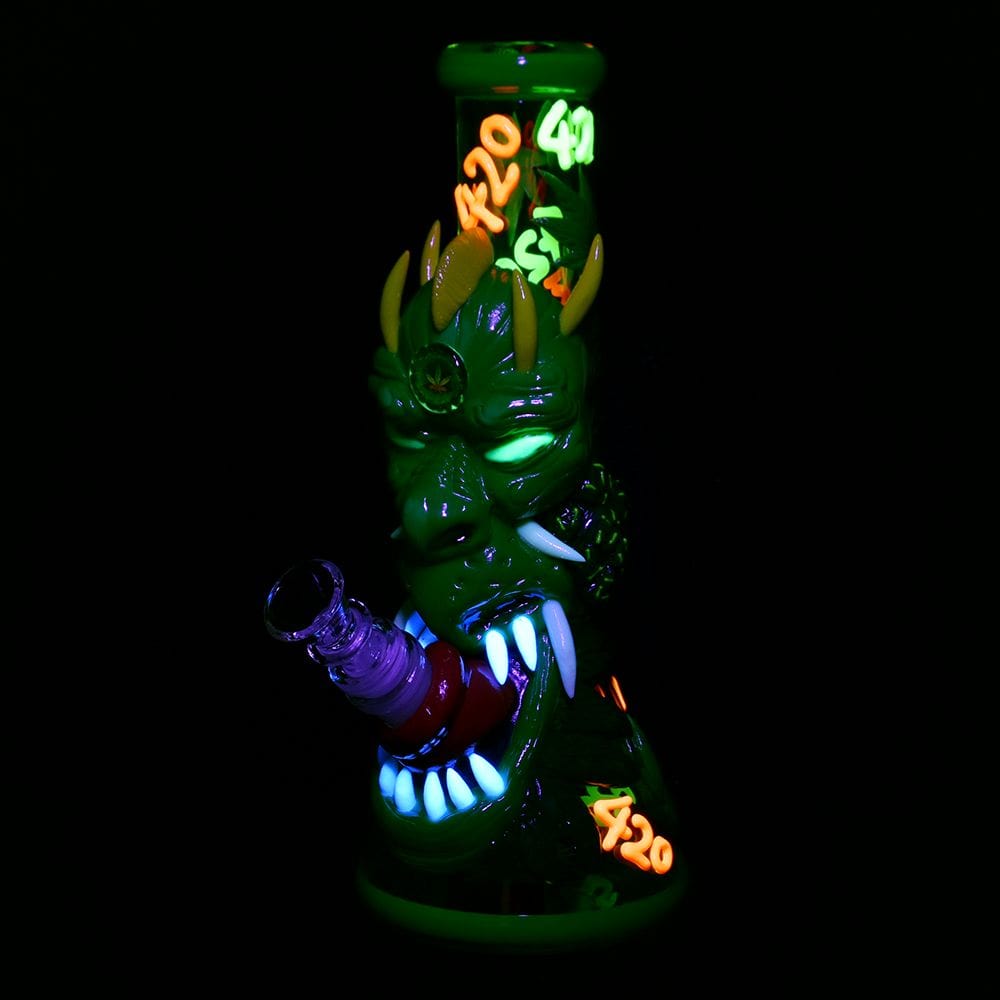 A front view of the glowing 420 Dragon Glow in Dark Beaker Water Pipe, showing the intricate dragon design on the beaker base.