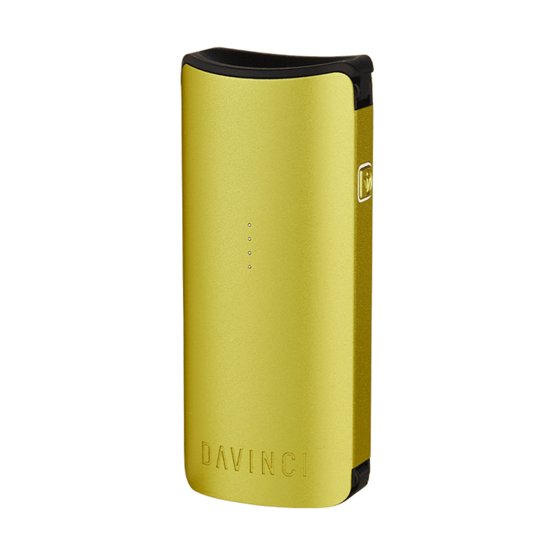 Front three-quarter view of a green DaVinci Miqro-C Vaporizer standing upright on a white background, showing its curved top mouthpiece, four LED indicator dots, and engraved DAVINCI logo.