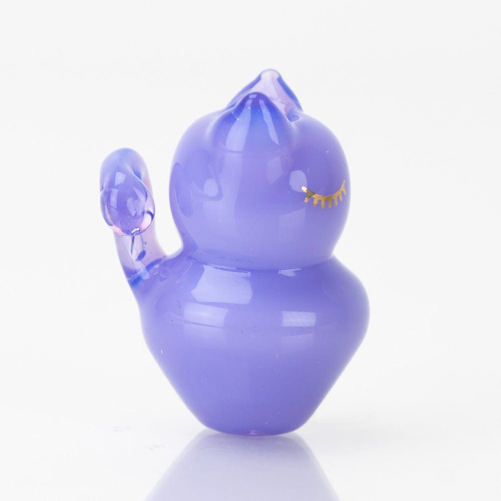 A studio shot displays the SakiBomb Kitty Carb Cap, a small, rounded glass piece reflecting bright highlights on a neutral surface.