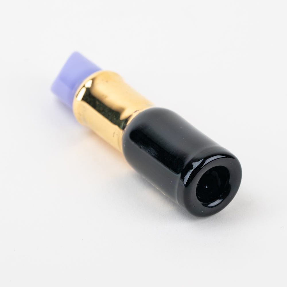 A close-up shows the SakiBomb Purple Lipstick Chillum with a golden base and purple tip, angled against a neutral background.