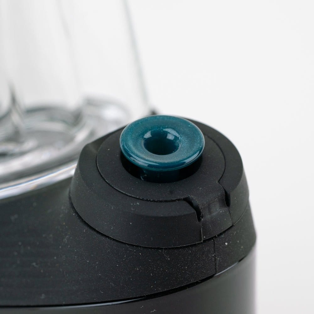 Close-up of the blue Empire Glassworks PuffCo 'New Peak' & Proxy Glass Joystick Cap - Blue Lagoon seated on a black device ring.