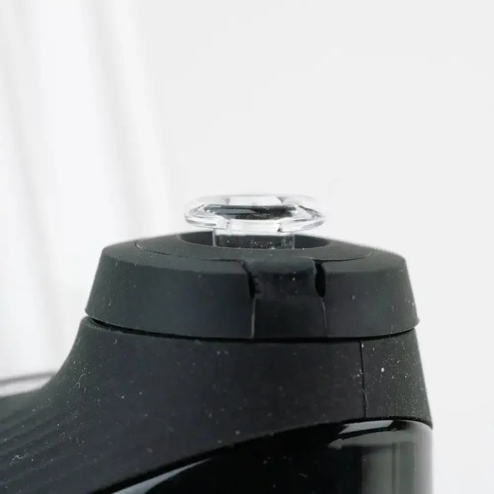 Close-up of the Empire Glassworks PuffCo 'New Peak' & Proxy Glass Joystick Cap - Clear mounted atop a black device against a white backdrop.