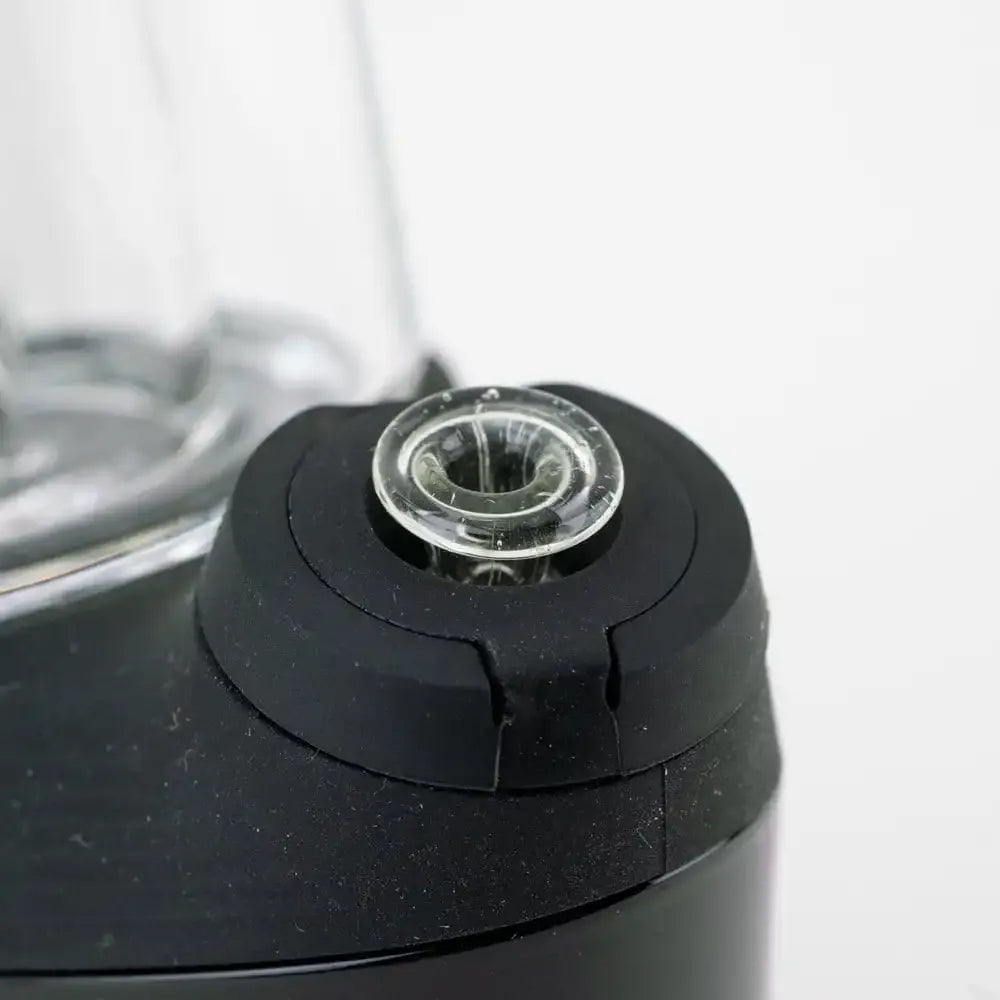 Close-up of the Eclipse Empire Glassworks PuffCo 'New Peak' & Proxy Glass Joystick Cap showing the clear glass cap seated in a matte black rubberized base.