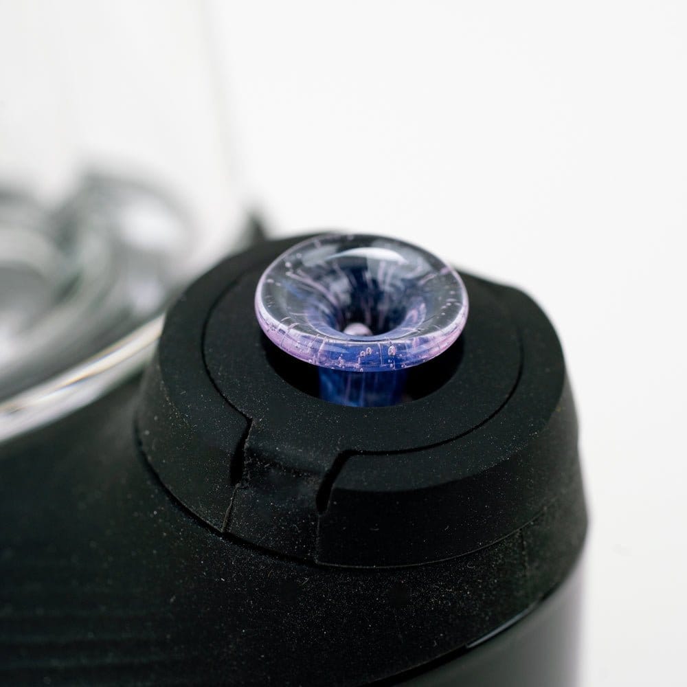 Close-up angled view of the Empire Glassworks PuffCo 'New Peak' & Proxy Glass Joystick Cap - Pink Slyme seated in a black device mount.