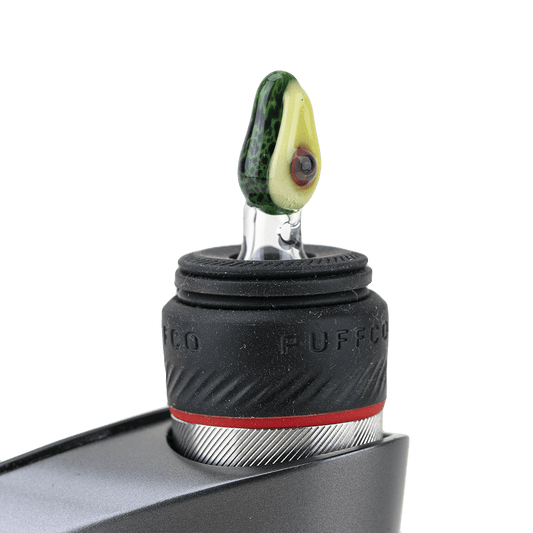 A close-up, angled view shows the Avocadope PuffCo Peak Pro Glass Ball Cap attached to a device, highlighting its rounded shape.