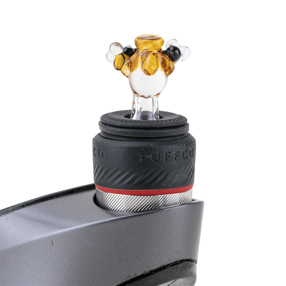 A close-up view of the Beehive PuffCo Peak Pro Glass Ball Cap, showing its rounded, translucent design.