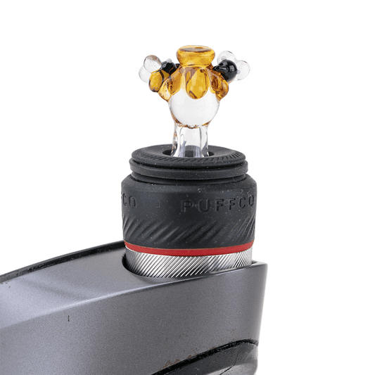 A close-up view of the Beehive PuffCo Peak Pro Glass Ball Cap, showing its rounded, translucent design.