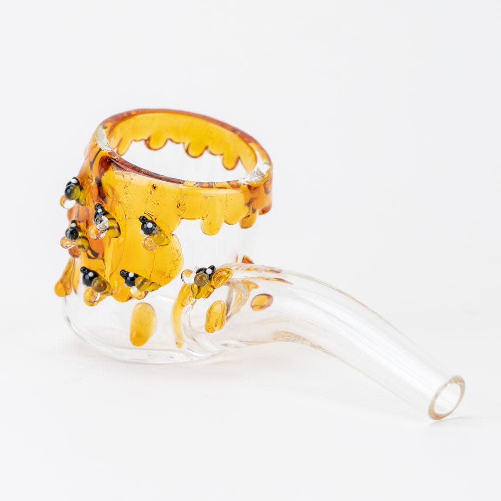 A close-up shot of the Beehive Proxy Glass Attachment Set, with a golden-yellow hue and textured detail.