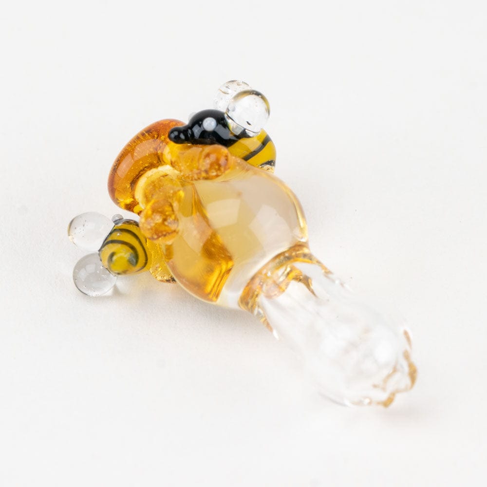 A close-up, angled view of the Beehive PuffCo Proxy Glass Ball Cap, showcasing its transparent, rounded shape and subtle reflections.