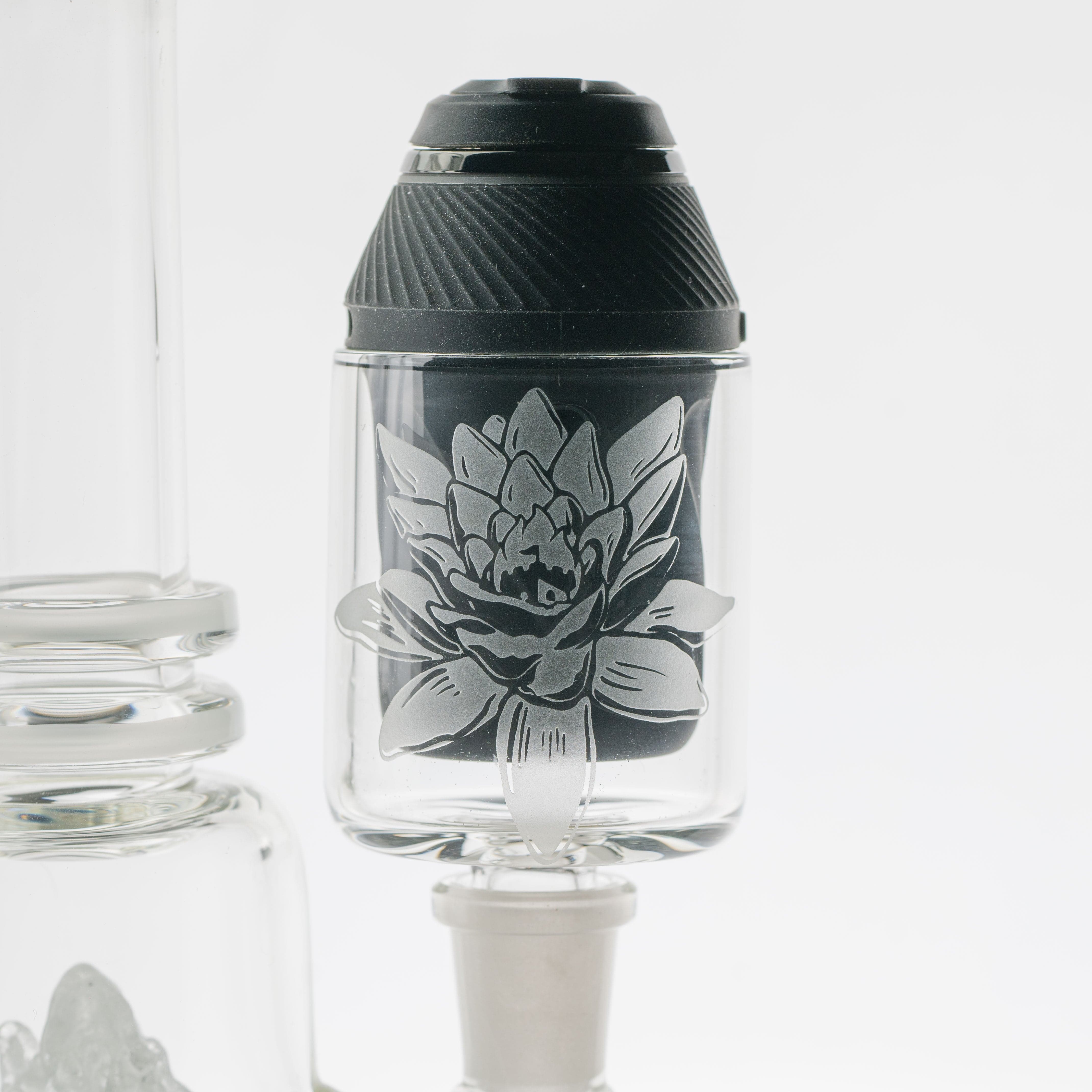 A front view of the Puffco Proxy Frosty Lotus glass attachment, with a frosted design against a softly lit, neutral background.
