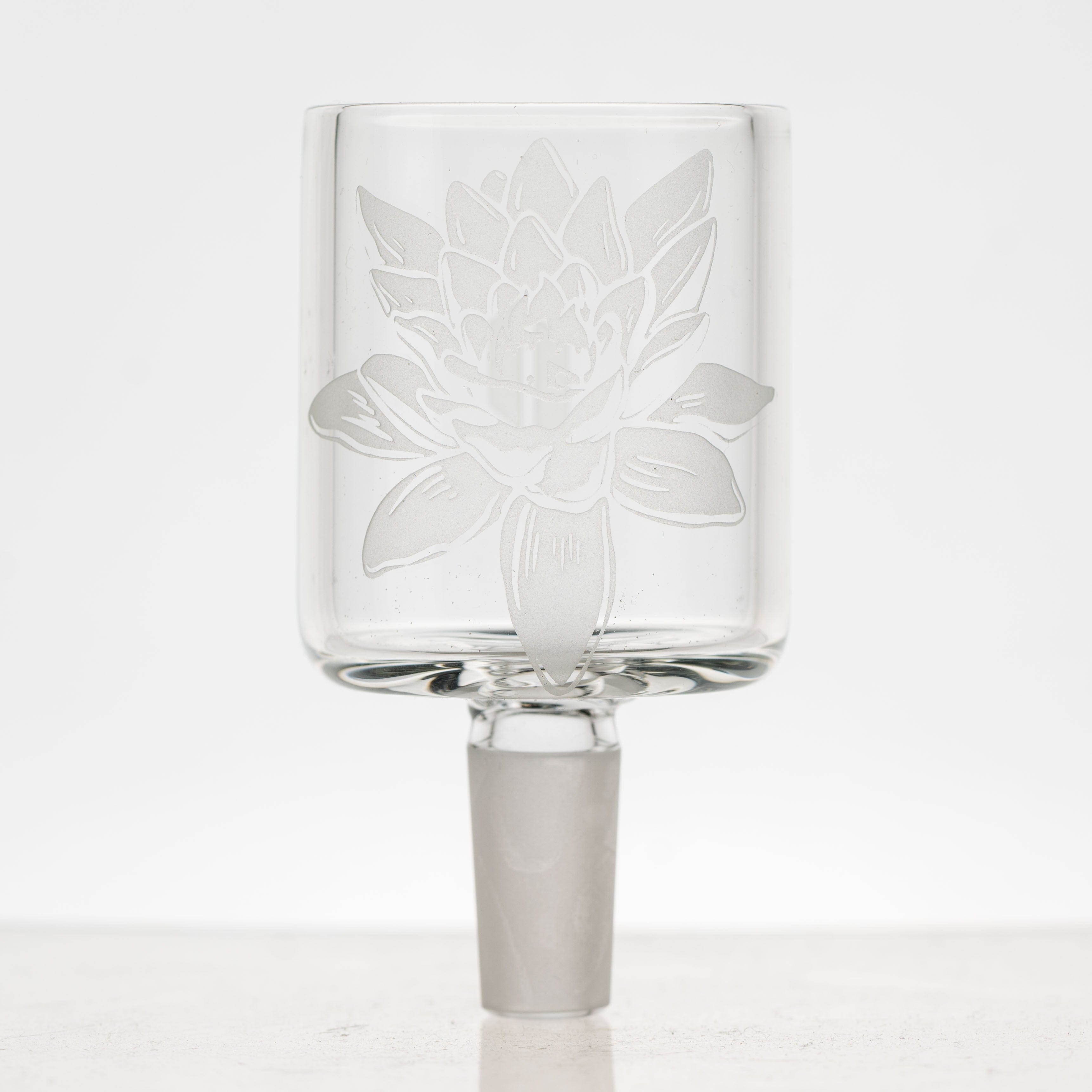 A front view of the Frosty Lotus Puffco Proxy Glass Attachment, showing its clear glass construction and intricate lotus flower design.