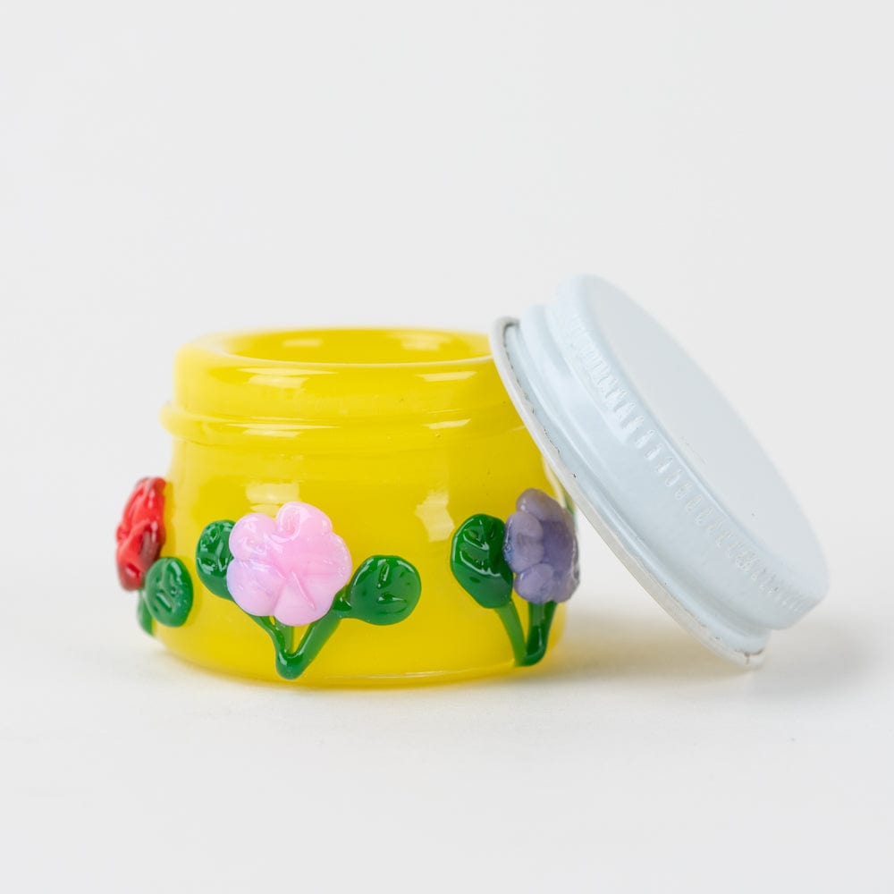 A close-up, angled view of the Sunshine Garden Terp Jar with its lid slightly ajar, revealing the contents inside.