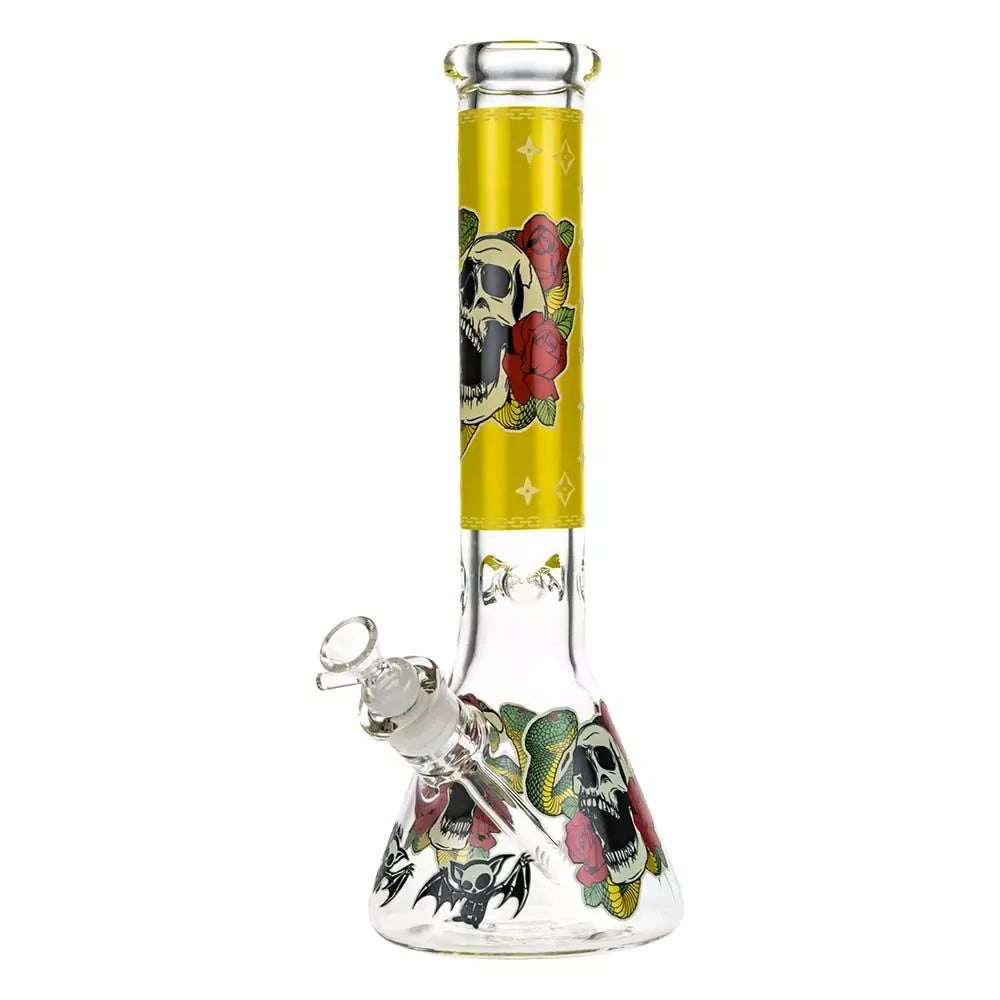 Front view of the Beaker Ice Bong with Glow in the Dark Snake and Skull Print showing a tall clear glass beaker with a yellow neck panel featuring a skull and roses and matching skull and snake graphics on the base.