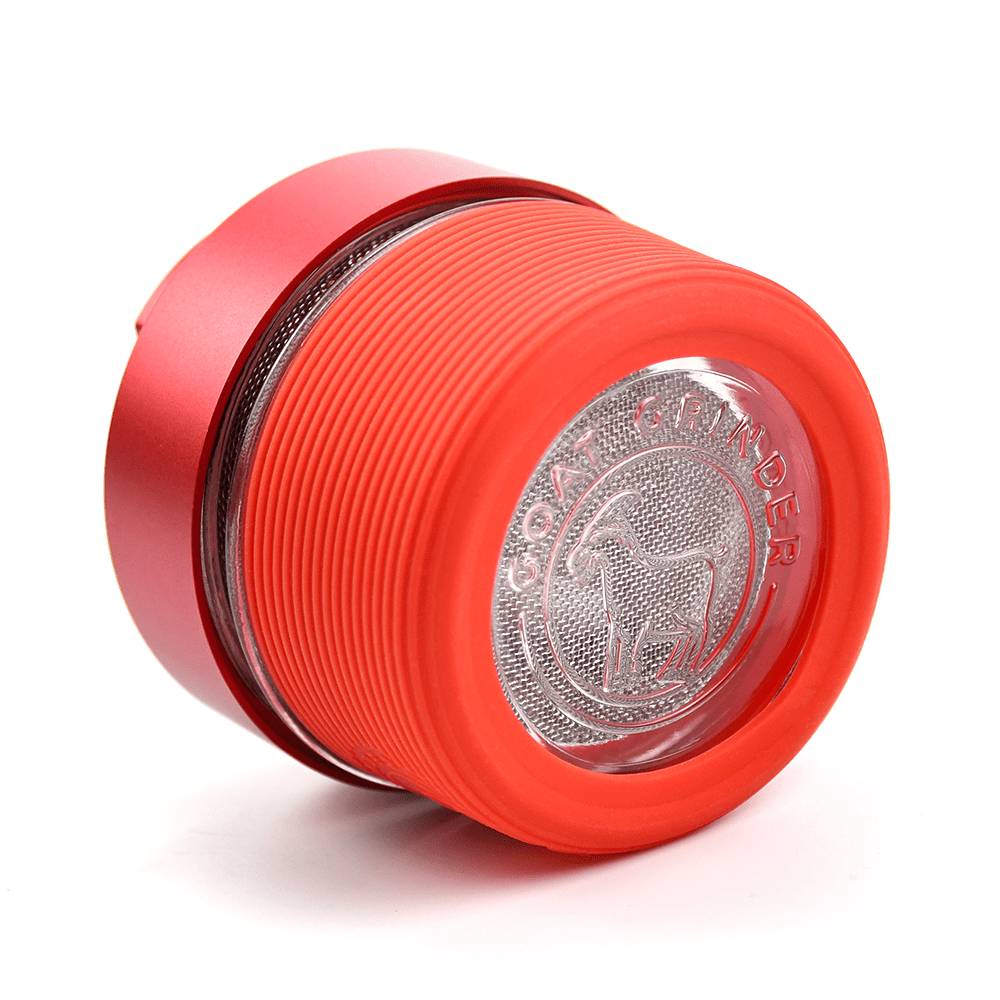Close-up of the AITH v.I – OG Grinder Jar, displaying its ribbed red exterior and metallic grinding components.
