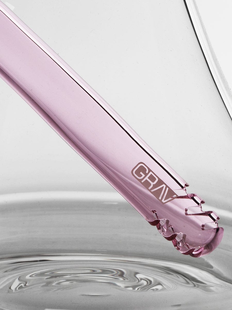 A close-up, angled view showcases the Medium Accented Deco Beaker Bong, with its smooth glass reflecting light and creating a shimmering effect.