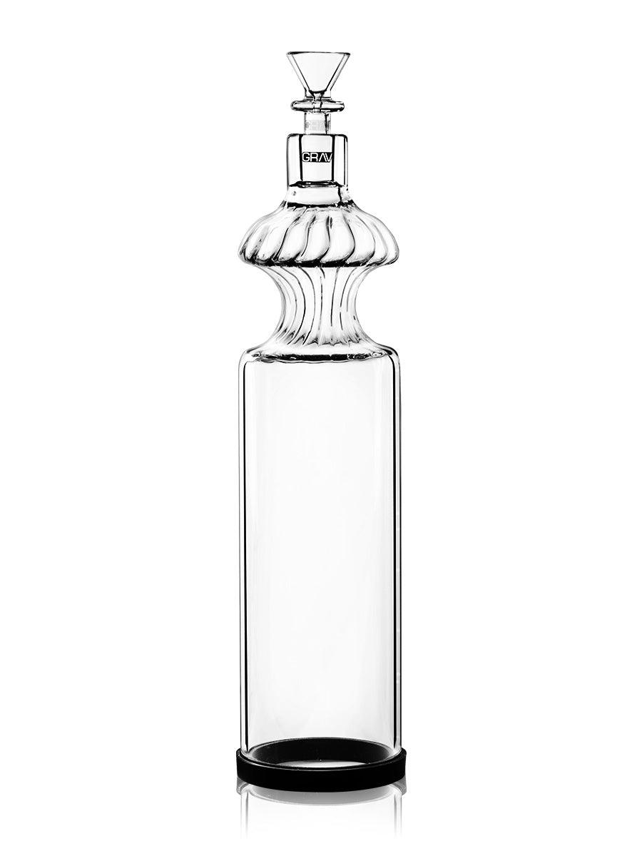 A studio shot displays the Monarch Gravity Bong, its clear glass form reflecting light on a dark surface.