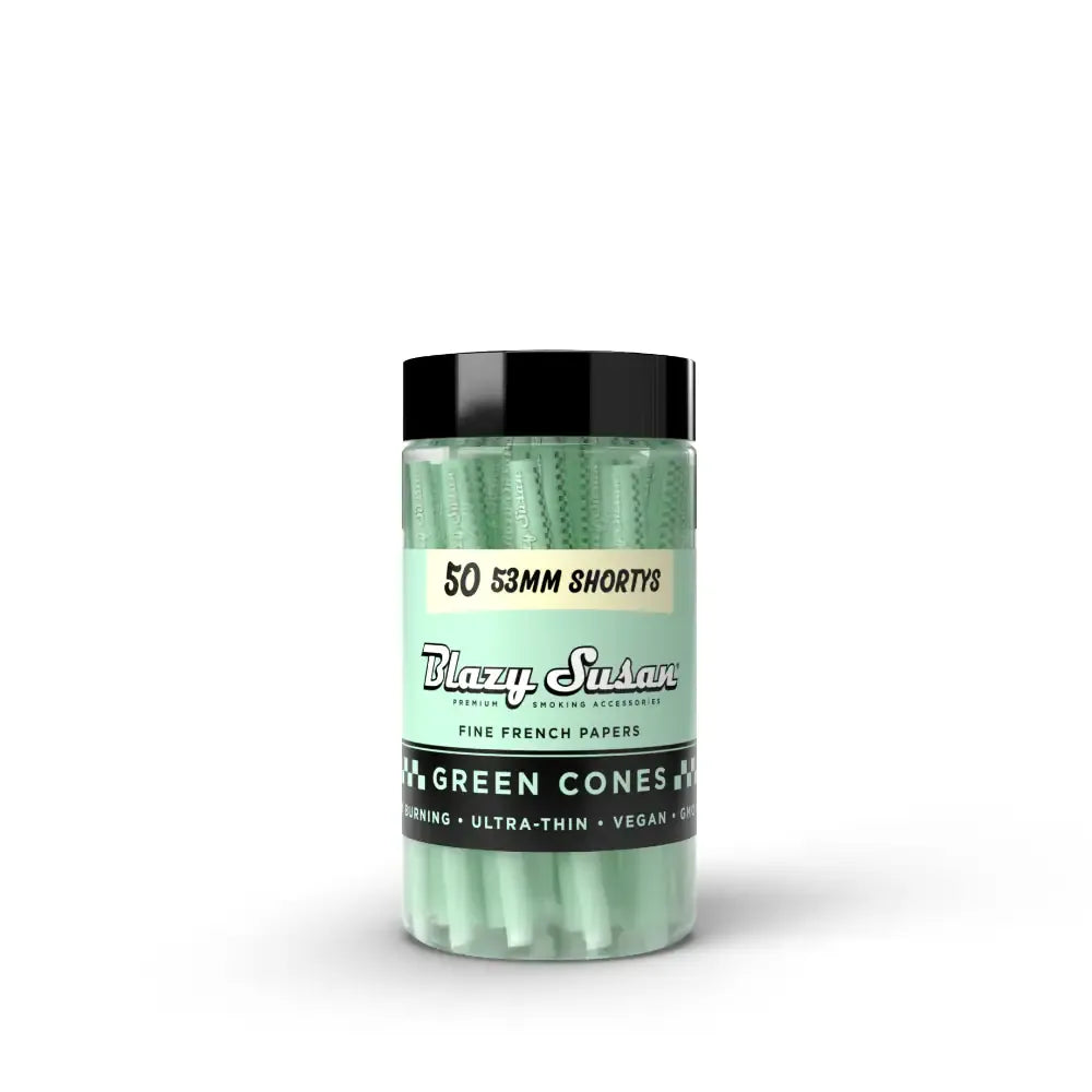 Centered front view of a clear jar of Blazy Susan Green Cones Jar showing mint-green cones stacked inside and a black lid on a white background