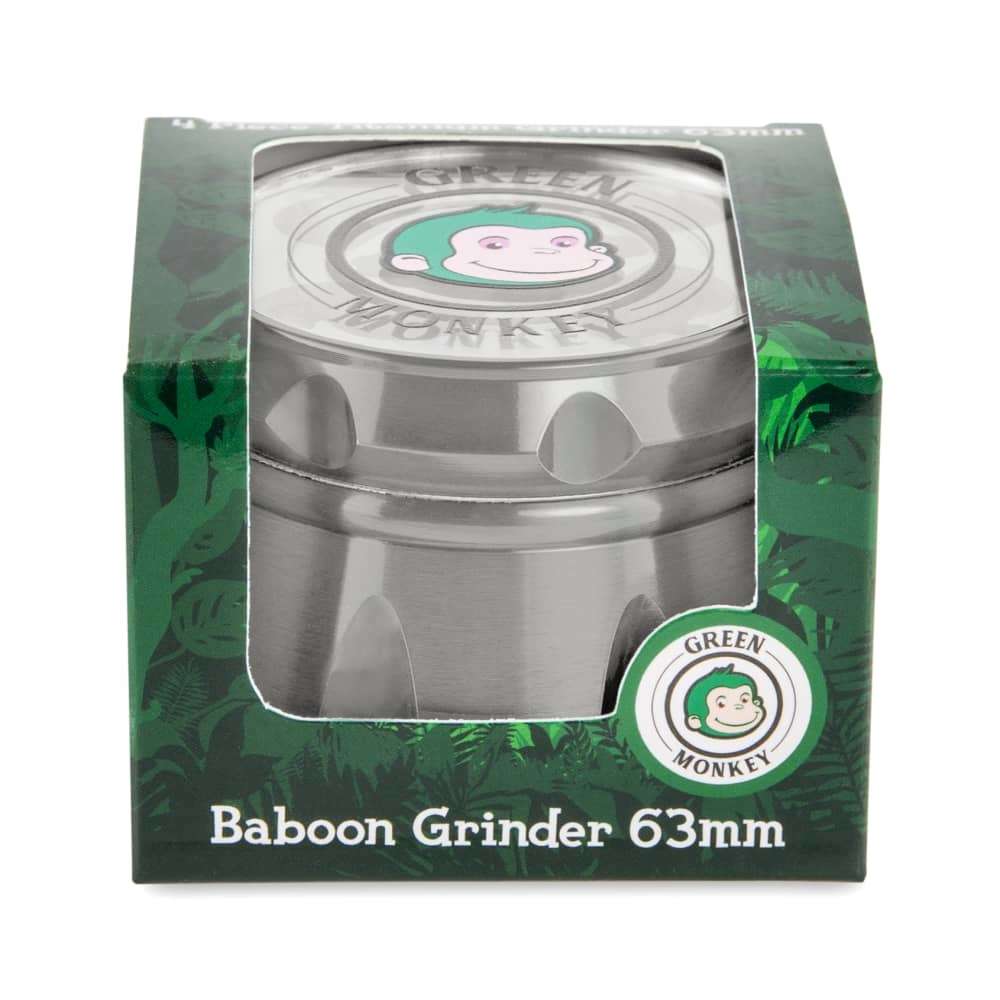 Front view of the Baboon Crown 63mm Grinder against a dark green patterned background, showing its circular design.