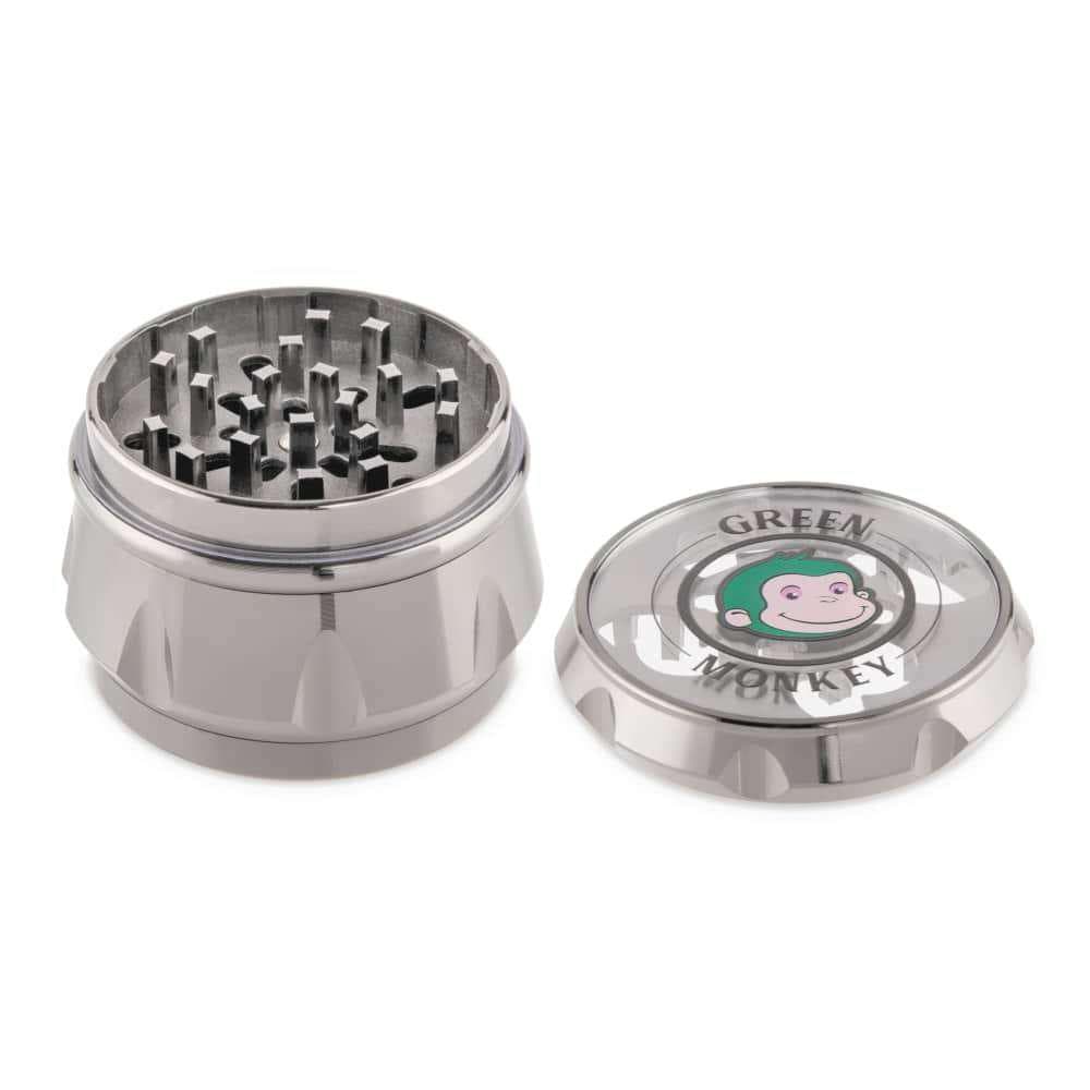 The open Baboon Crown 63mm Grinder is displayed from above, revealing its multi-tiered metal grinding components.