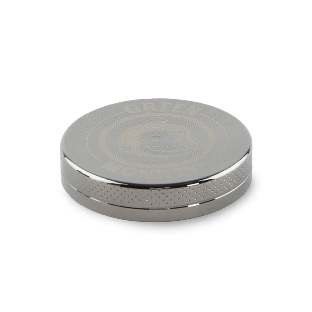 Close-up, angled view of the Capuchin 40mm Grinder, showcasing its metallic finish and circular design against a neutral background.