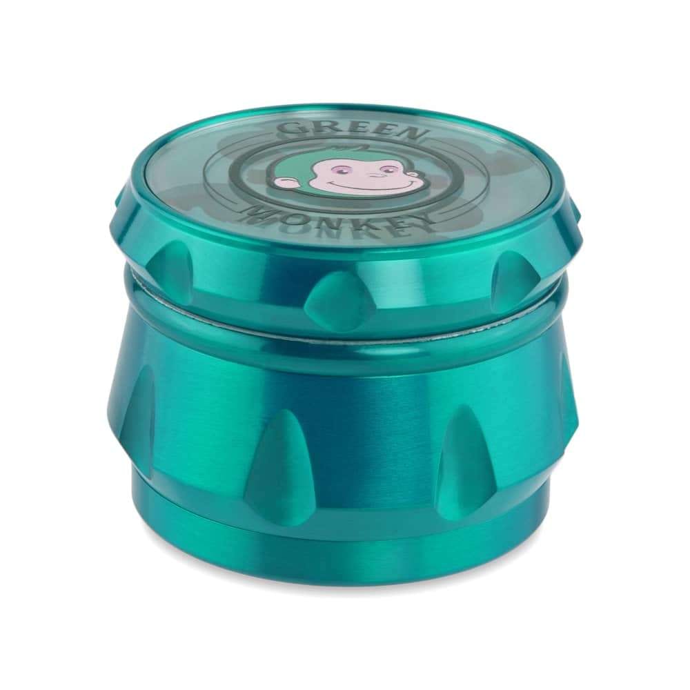 A close-up of the Baboon Crown 63mm Grinder, showcasing its metallic, multi-tiered design in a studio setting.