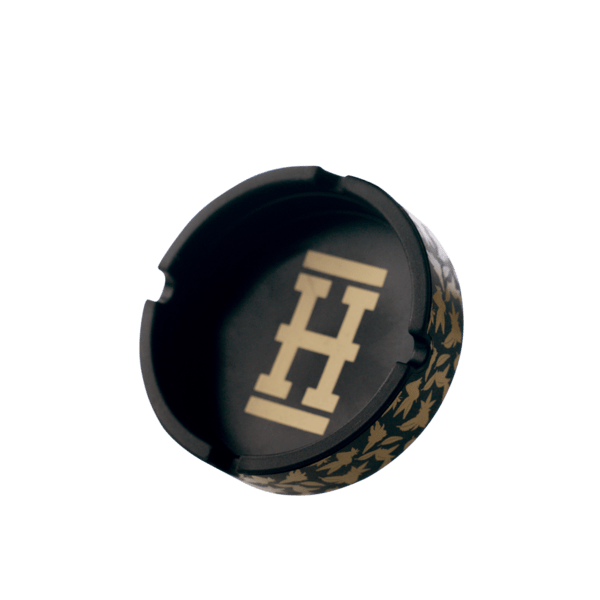 Overhead view of the Asher "Cannaflage" Silicone Ashtray, featuring a circular, dark-colored design with a subtly textured surface.