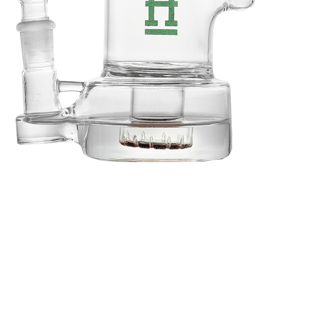 Close-up side view of the clear Hemper Bell Rig showing its cylindrical water chamber, percolator teeth, and partial downstem.