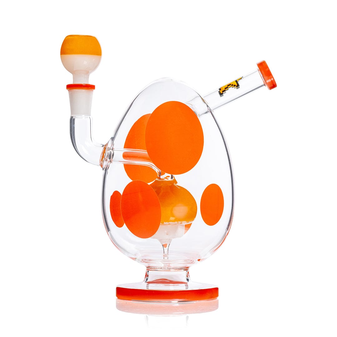Side view of the Hemper Spotted Egg XL Bong showing its egg-shaped clear glass body with large orange polka dots and matching orange-rimmed mouthpiece.